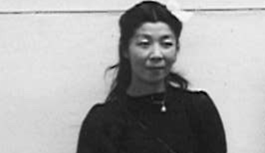 miki hayakawa wearing black dress standing against a wall